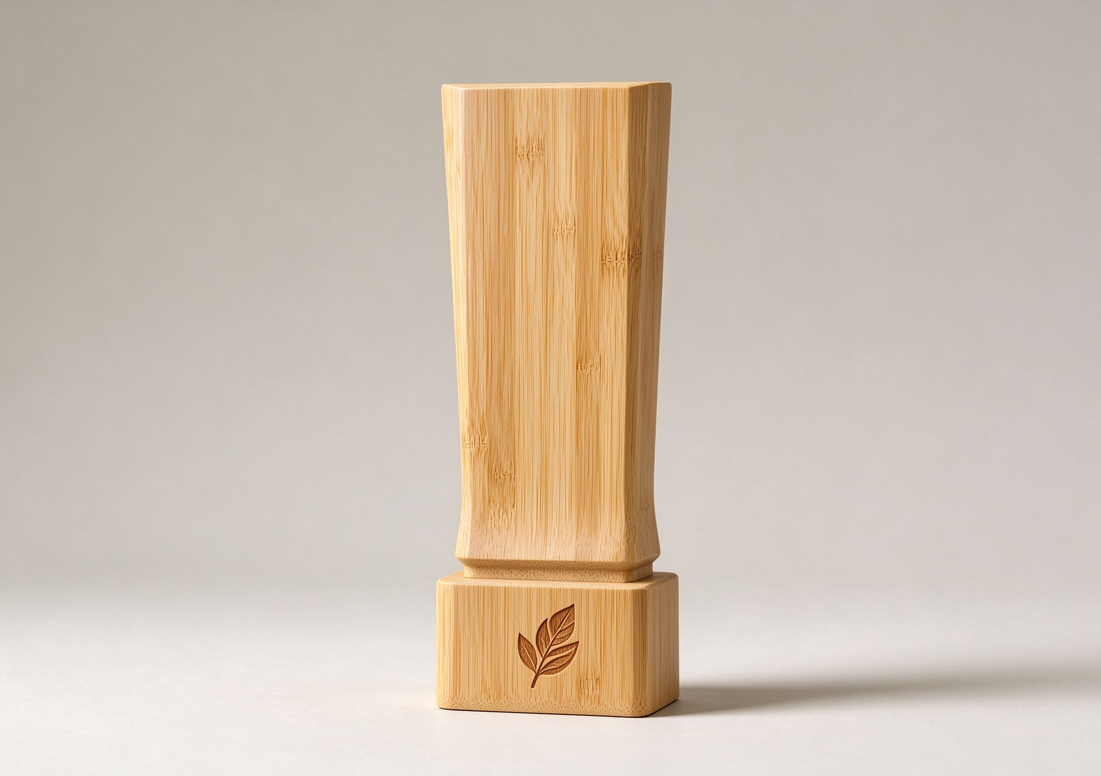 Bamboo trophy with engraved leaf emblem for eco‑friendly awards.jpg.png